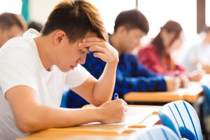 Stressed college student for exam in classroom